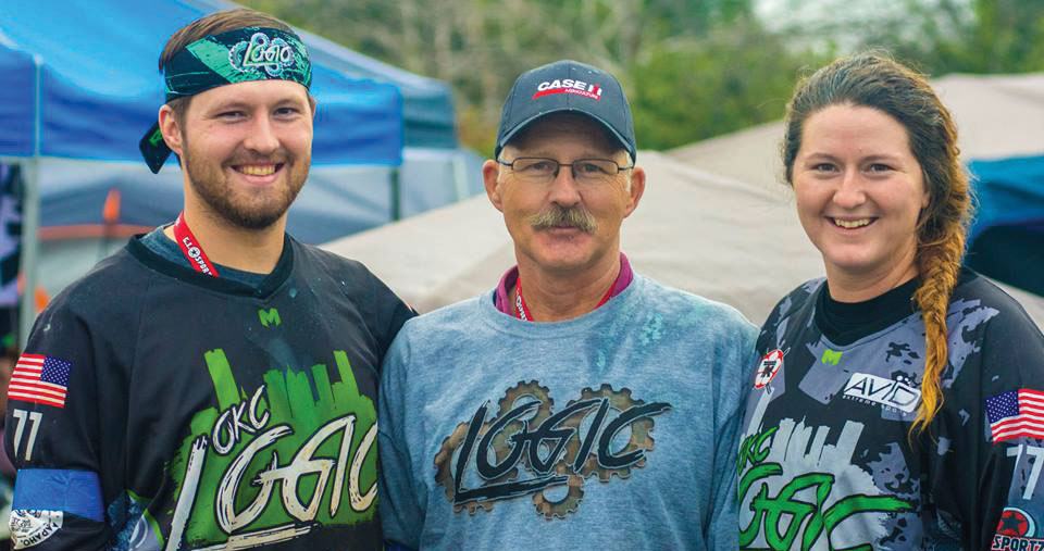 3 Paintball Players posing at the Oklahoma Game. in order from left to right. Man, older man and female.